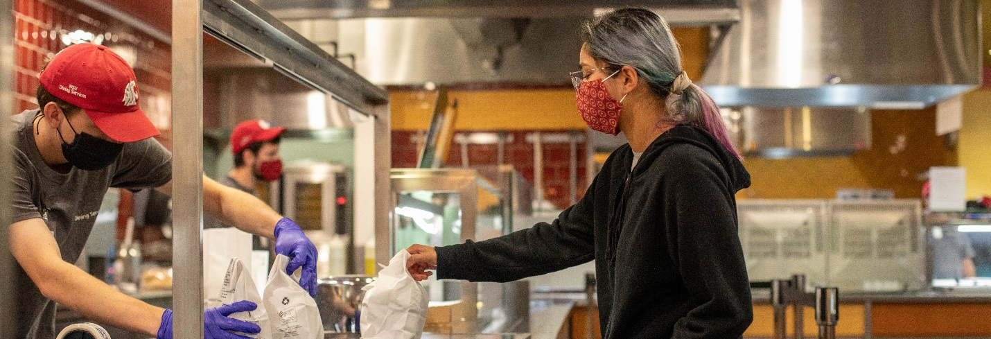 "Student picks up food with mask on