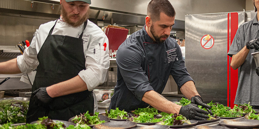 Chef's prepping a salad plates for an event.