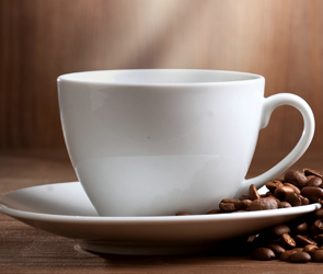 Coffee cup on saucer with coffee beans