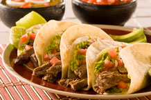 four tacos on a plate