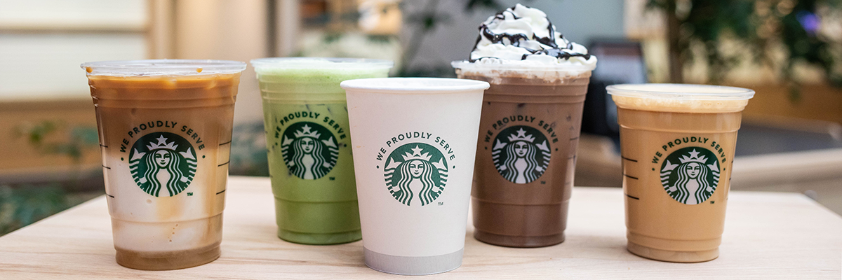A variety of Starbucks drink set on a table.