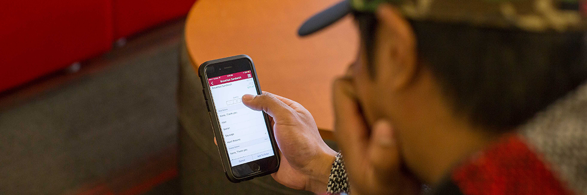 Student looks at GetFood app on their phone