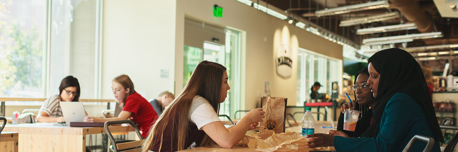 Students eating at a table inside The Market.