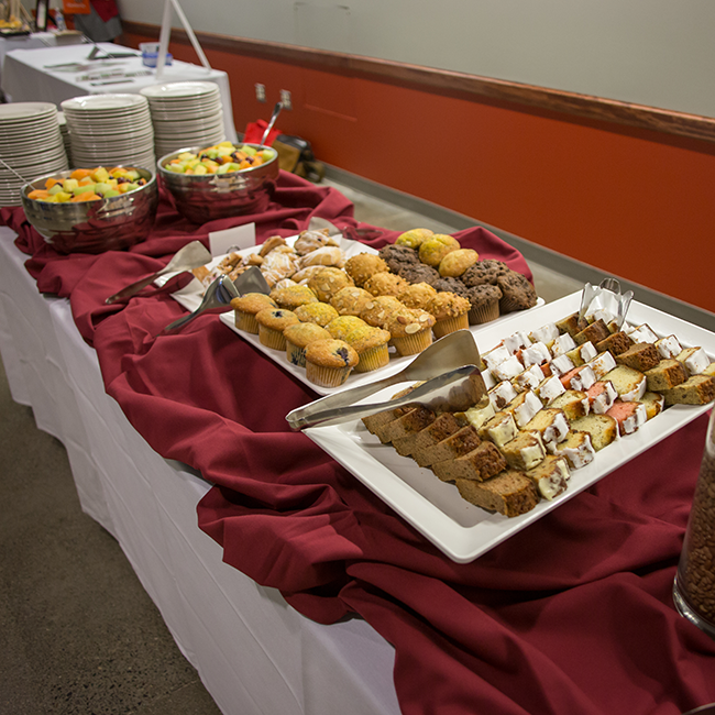 An array of muffins, fruit, and breads.