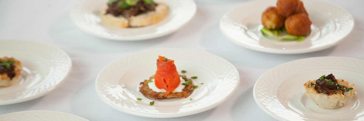 A variety of formal dishes on white plates.