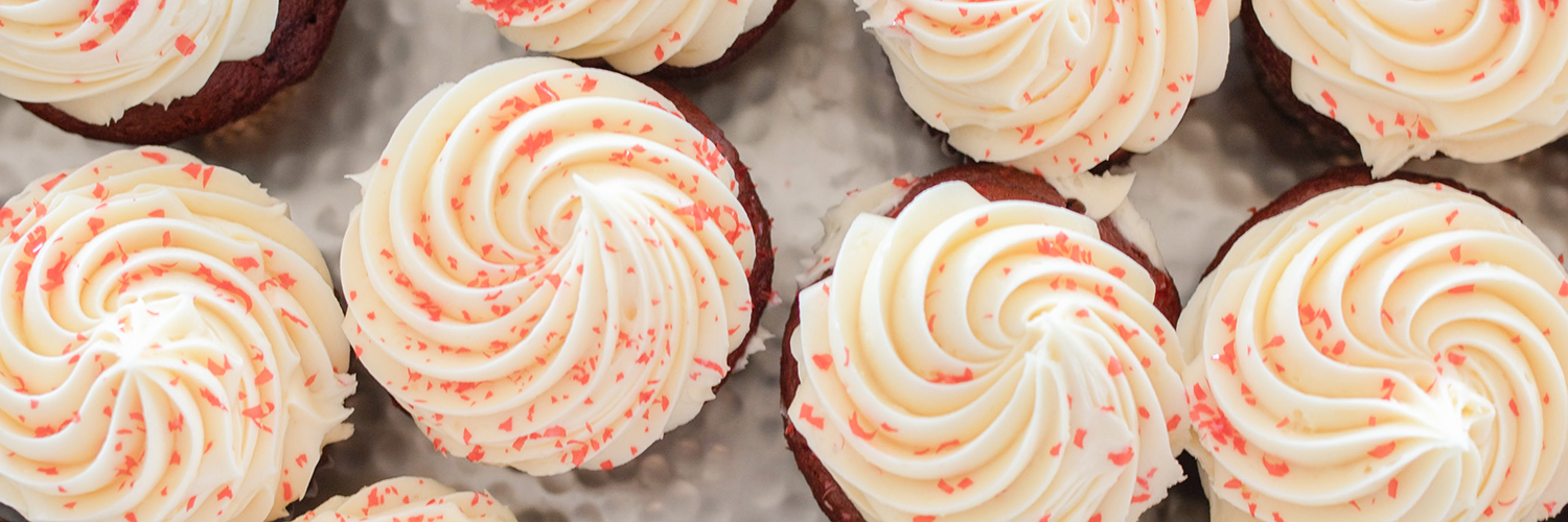 Cupcakes with white frosting and red sprinkles.