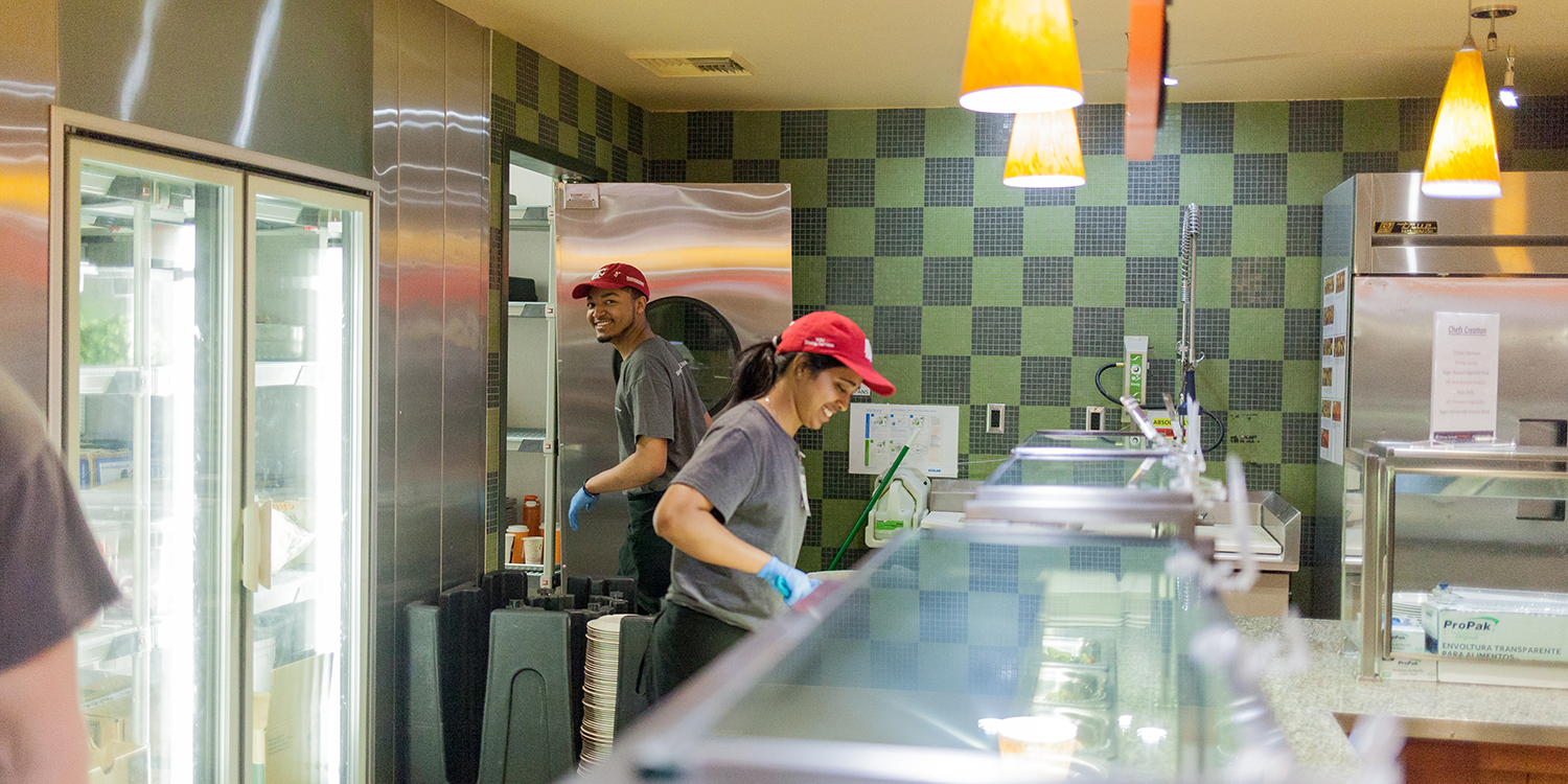 Two student employees smiling while working.